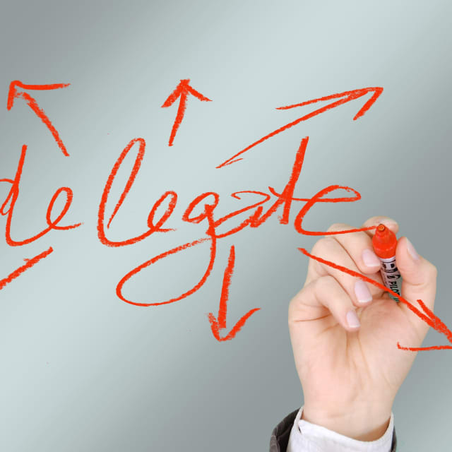 Hand writing the word delegate