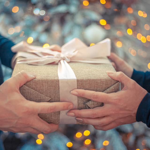 Man giving Christmas gift to woman