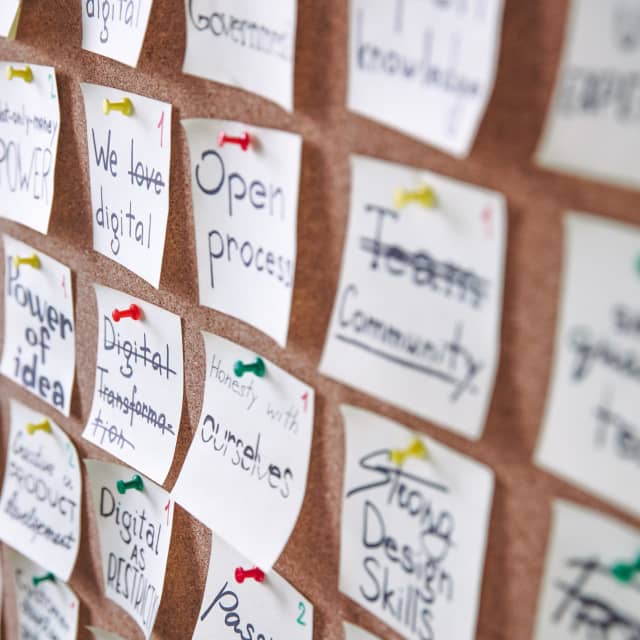 Post it notes tacked to cork board