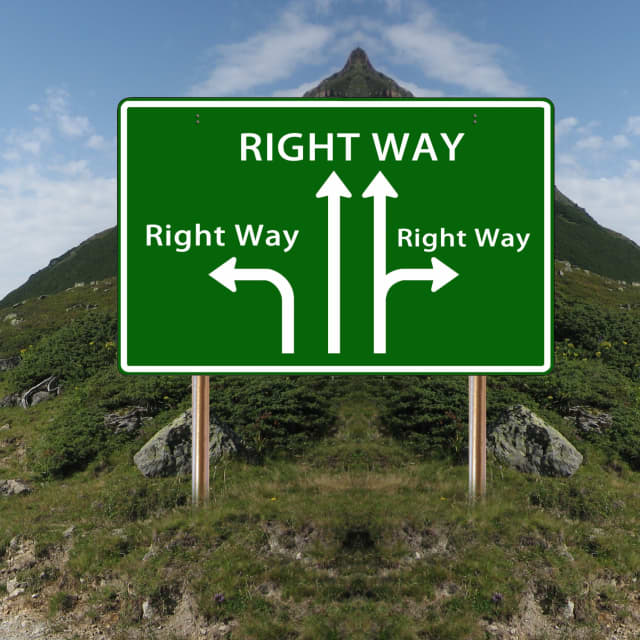 Road sign at fork in mountain pass