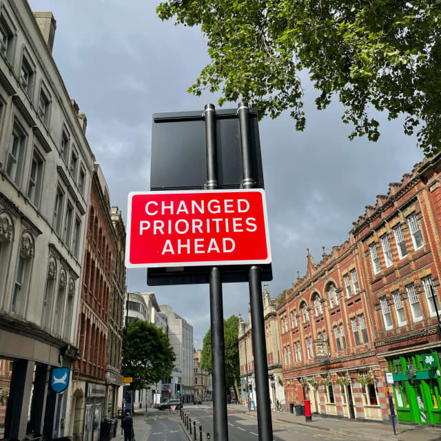 Street sign that says "Changed Priorities Ahead"