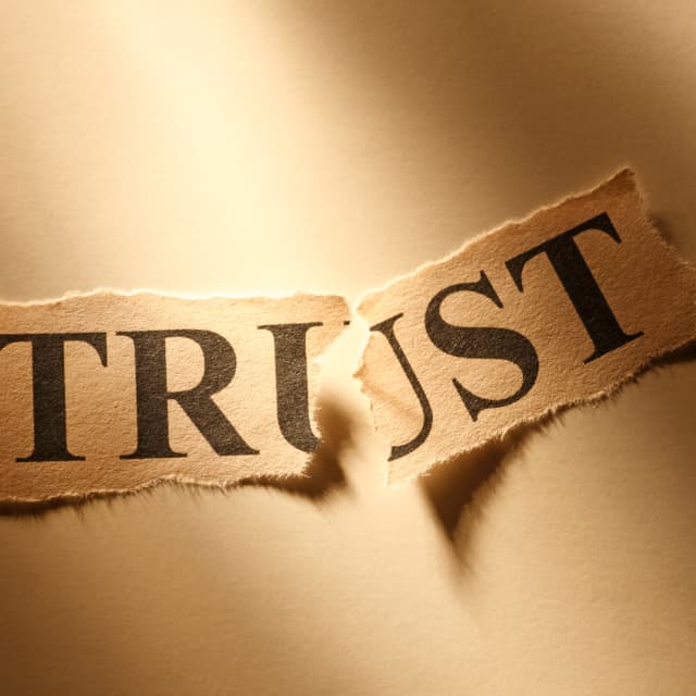 The word trust on a paper that is ripped in half