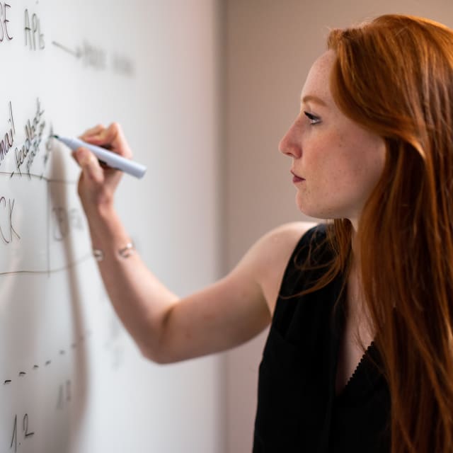 Woman writing on a whiteboard