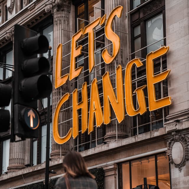 Sign on side of building that says "Let's Change"