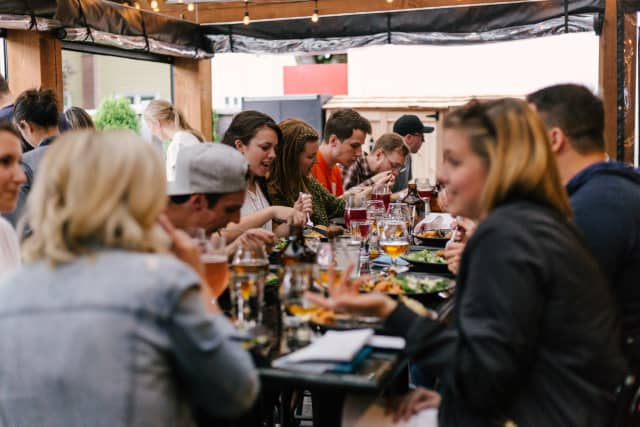 Group of people talking and eating at a restaurant table