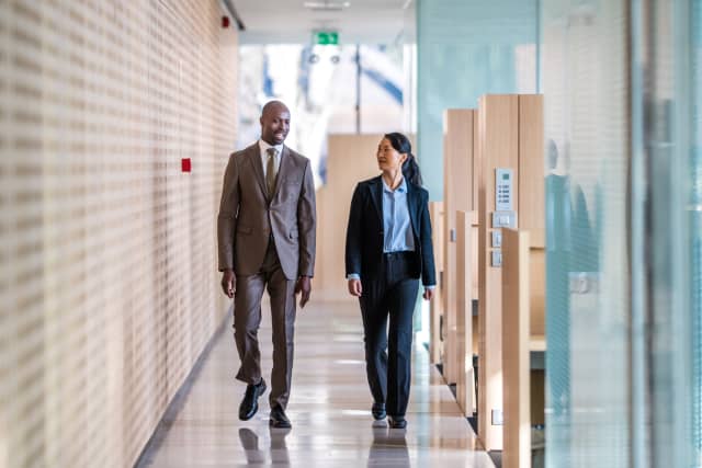 Man and woman walking in office hallway